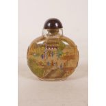 A Chinese reverse decorated glass snuff bottle depicting figures in busy town scenes, 3" high