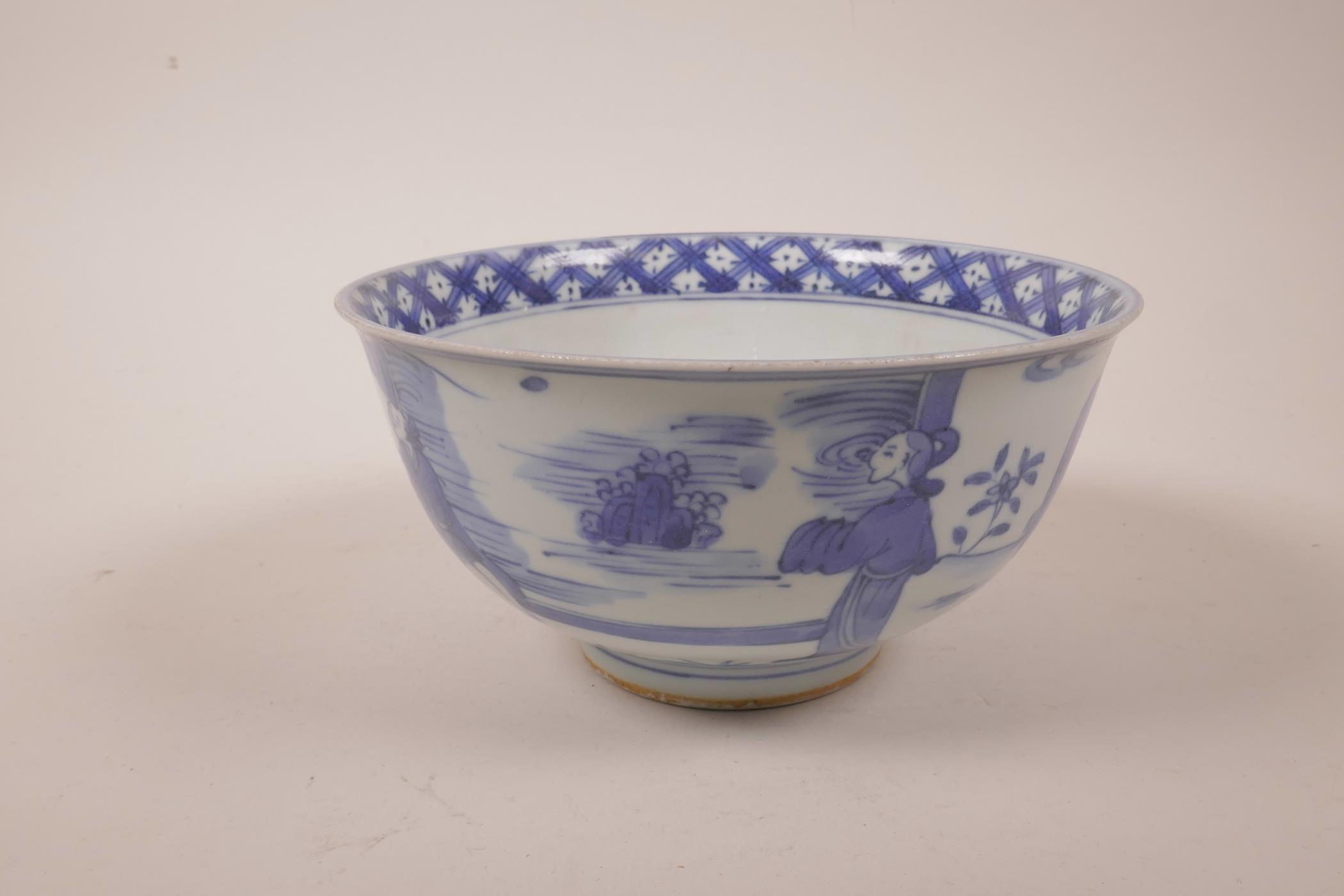 A Chinese blue and white porcelain rice bowl decorated with figures in a garden, six character