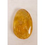 A Chinese carved amber style pendant decorated with a goldfish, 2" drop