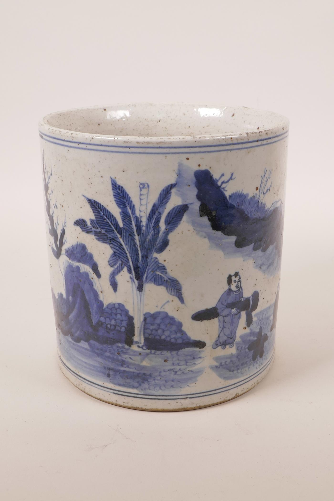 A Chinese blue and white pottery brush pot decorated with figures in an ornamental garden, 7" high x