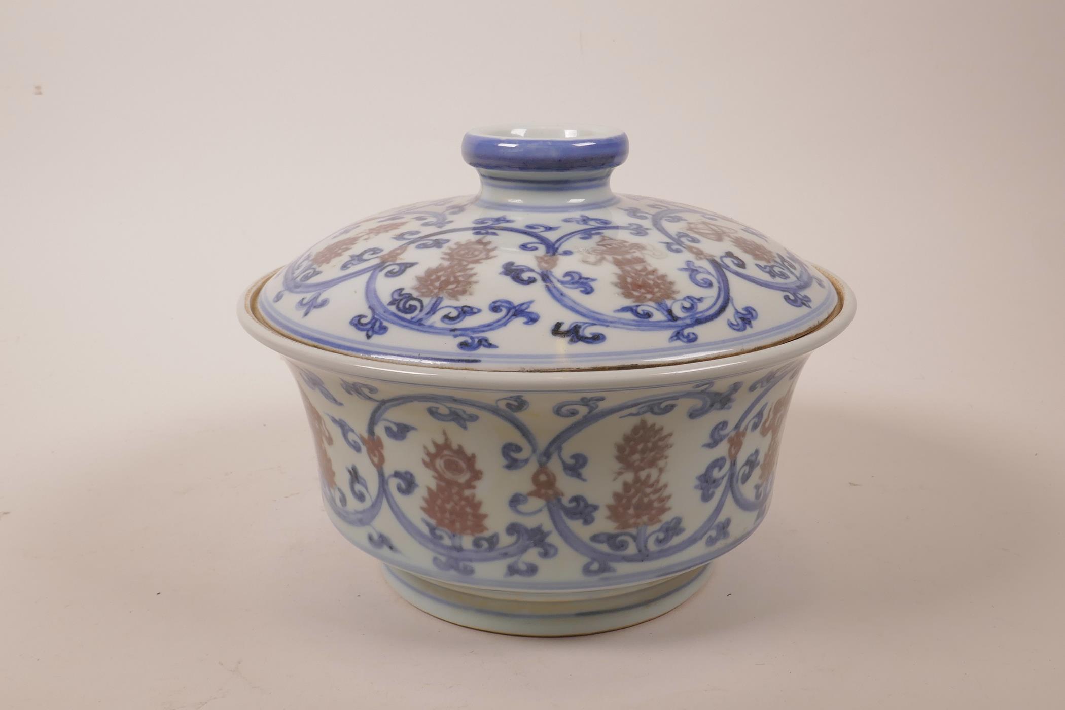 A Chinese blue, white and red porcelain pot and cover decorated with lotus flowers and the emblems