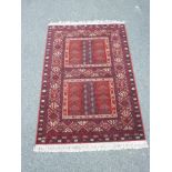 A Belgian red ground wool rug decorated with a Persian geometric pattern, 55" x 78"