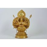 A Sino-Tibetan gilt bronzed metal figure of a many armed deity seated on a lotus throne, impressed