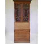 An Edwardian mahogany bureau bookcase with inlaid satinwood banding, astral glazed doors and four