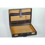 A Dunhill black leather attaché/briefcase with brass combination locks and fitted interior