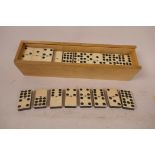 A boxed set of vintage celluloid faced dominoes, box 11" long