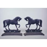 A pair of cast iron fire dogs in the form of horses, 11" wide x 10½" high