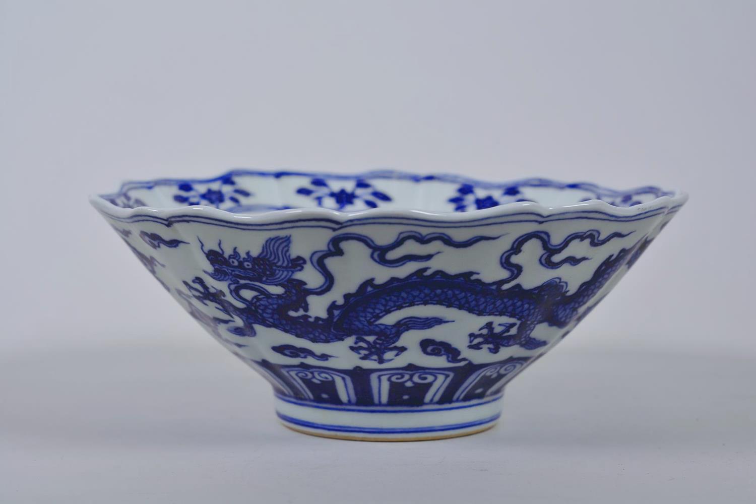 A Chinese blue and white porcelain bowl with a lobed rim and dragon decoration, 6 character mark
