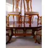 A yew wood extending dining table with eight pierced splat back dining chairs, 39" x 66", 104"