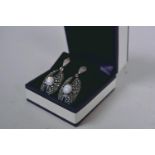 A pair of Art Deco style silver, marcasite and onyx pendant earrings set with central opalite