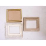 Three wooden picture frames, two with plain gilded moulding and one with foliate design and in a