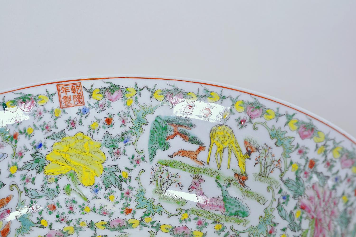 A large Chinese porcelain bowl decorated with deer, mythical beasts and flowers in bright enamels, - Image 5 of 9