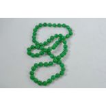 A Chinese apple jade beaded necklace, 32" long