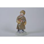 A Soviet Russian Pesochnoe bisque porcelain figure of a young cossack boy with an axe, c.1958,
