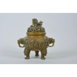 A Chinese bronze censer and cover with two dragon handles, tripod feet and raised dragon decoration,