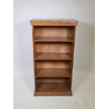 An oak open bookcase with three fixed shelves, raised on a moulded plinth, 26" x 14" x 49"