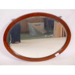 An Edwardian oval mirror in mahogany with string pattern inlays, and a bevelled mirror, 25½" x 19½"