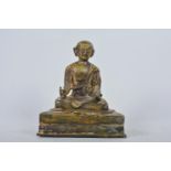 An Oriental bronze figure of Buddha seated in meditation on a raised dias, 7½" high