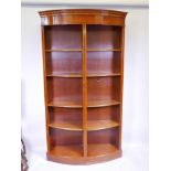A yew wood bow fronted open bookcase, with inlaid decoration and satinwood crossbanding, 48" x 16" x