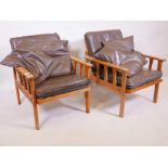 A pair of mid century beechwood armchairs with slatted sides and leather cushions, webbing A/F