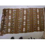 A fabric wall hanging with woven and open work decoration in shades of brown and ochre, 35" x 68"