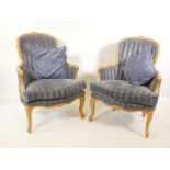 A pair of French style carved beechwood arm chairs