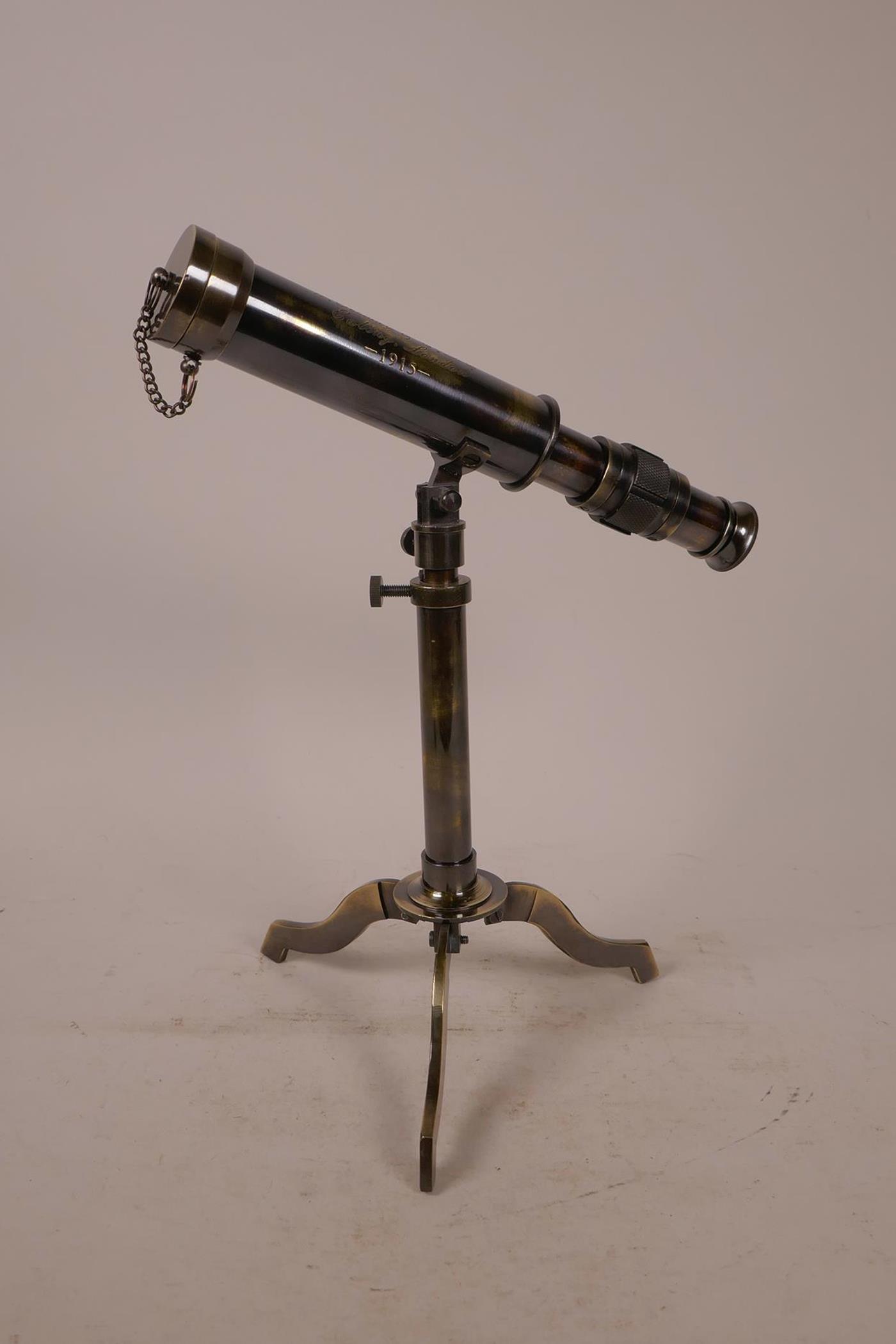 A brass reproduction telescope on tripod stand, 9½" long collapsed