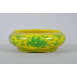 A Chinese yellow ground porcelain dish with a rolled rim and incised green kylin decoration, 6