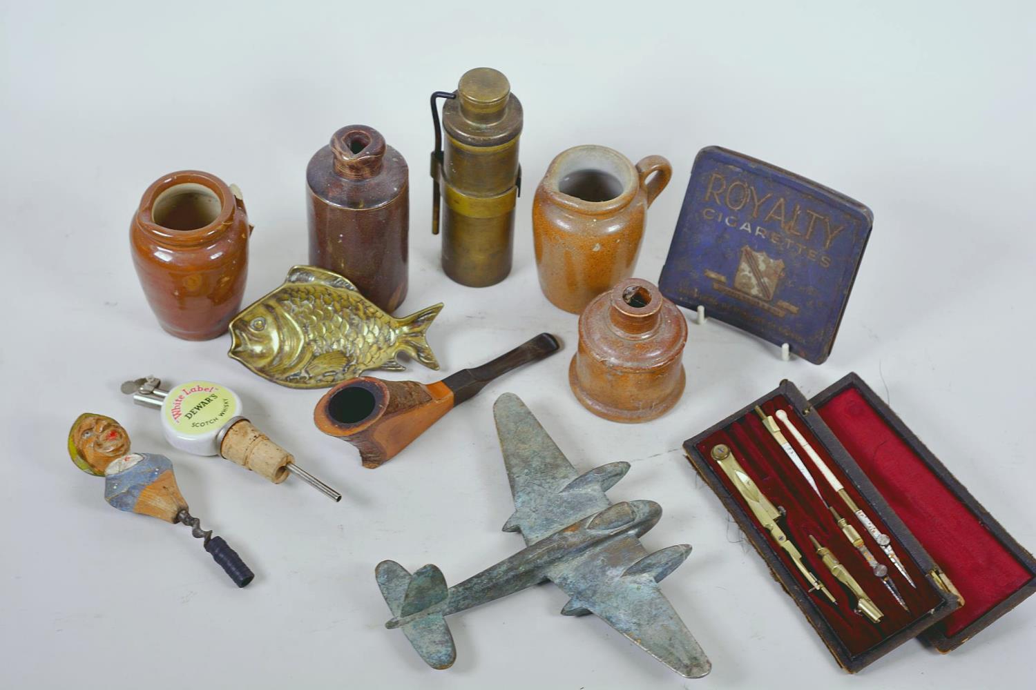 A box of collectables including a brass model Mosquito aircraft, Royalty cigarette tin, drawing set,