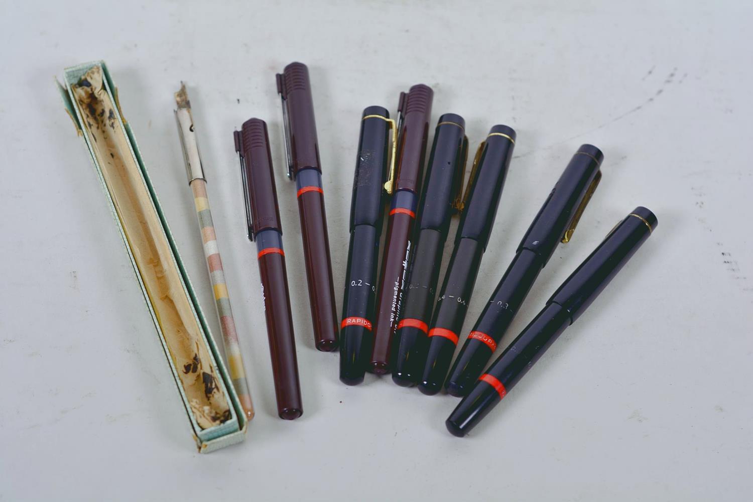 A collection of eight Rotring calligraphy pens together with an ink pen with glass handle filled