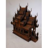 A large Thai hardwood shrine in the form of a temple with carved, stylised dragon decoration, 36"