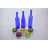 Three 1970s blue glass bottles, largest 13", together with five glass tea light holders
