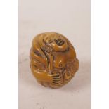 A Japanese tagua nut netsuke carved in the form of Buddha, 1" diameter