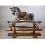 An early C20th carved wood rocking horse, losses, 53" long x 44" high