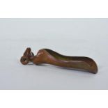 An Oriental patinated copper scoop in the form of a ram in robes, 5" long
