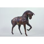 A leather clad model of a horse with saddle and harness and glass eyes, 12" high, 14" long