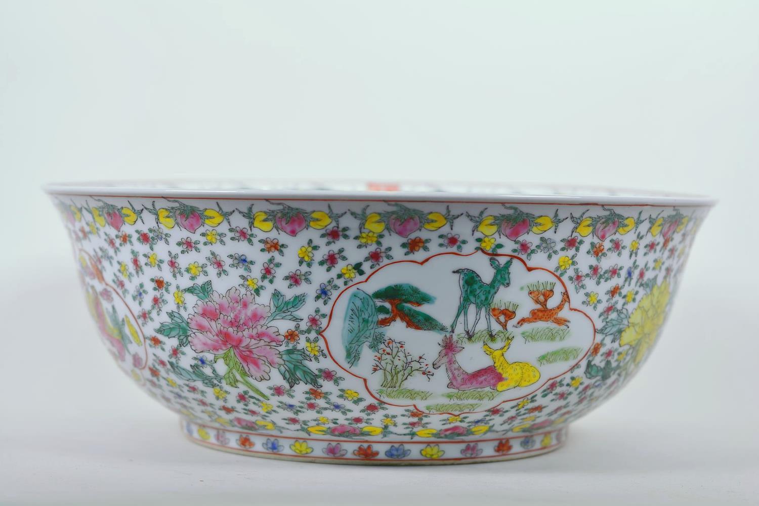 A large Chinese porcelain bowl decorated with deer, mythical beasts and flowers in bright enamels,