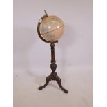 A Fucashun World Globe in a brass frame on a turned column tripod stand, 44" high