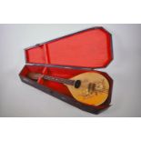 A vintage flat back mandolin with rosewood finger board and floral painted decoration, 24" long,