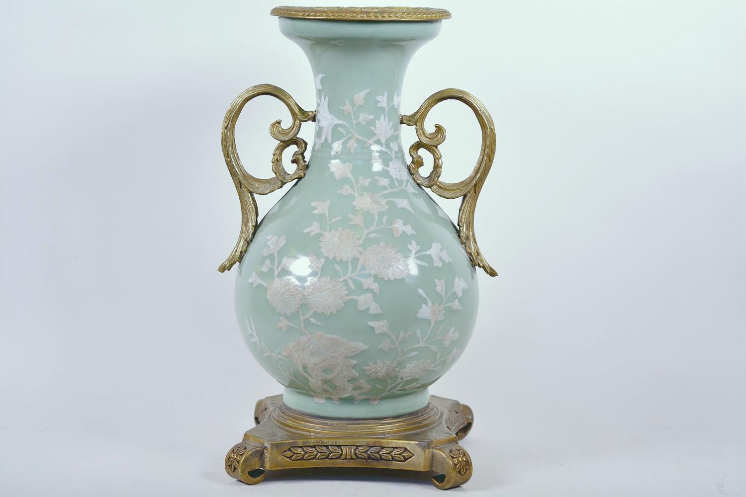 A Chinese celadon glazed porcelain vase with ormolu style mount and raised floral decoration, seal