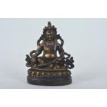 A Tibetan gilt bronze figure of a Buddhist deity, on a wood base, 6" high