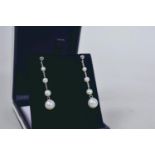 A pair of white gold and graduated cultured pearl drop earrings