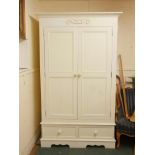 A painted pine wardrobe with two cupboards over a base of two drawers (in two sections), raised on