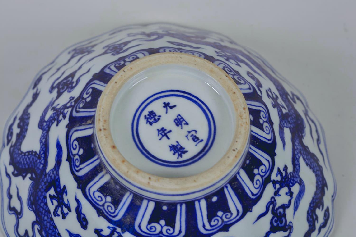 A Chinese blue and white porcelain bowl with a lobed rim and dragon decoration, 6 character mark - Image 7 of 11