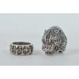 A Chinese white metal tiger head ring, and another
