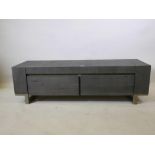 A contemporary low side cabinet with weathered oak finish, fall front and one drawer, raised on