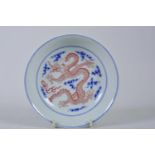 A Chinese blue and white porcelain dish/saucer decorated with a dragon chasing the flaming pearl,