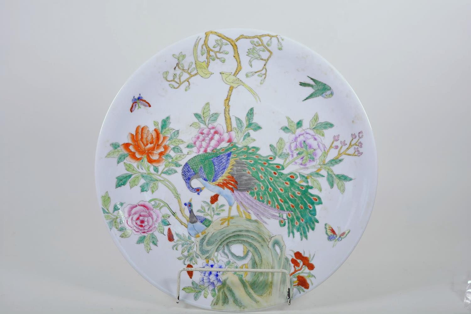 A Chinese porcelain charger painted with peacocks in a flowering tree, seal mark to base, 14"