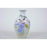 A Chinese porcelain vase decorated with ladies in a garden scene in bright polychrome enamels, 7"