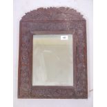 A C19th Anglo Indian hardwood frame carved with trailing lotus, fitted with a mirror, 14" x 19"